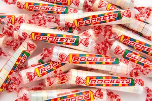 CLUSTER OF INDIVIDUAL ROCKETS CANDY ROLLS ON WHITE BACKGROUND.