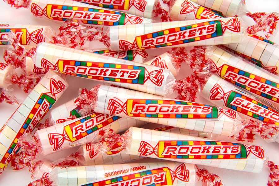 CLUSTER OF INDIVIDUAL ROCKETS CANDY ROLLS ON WHITE BACKGROUND.